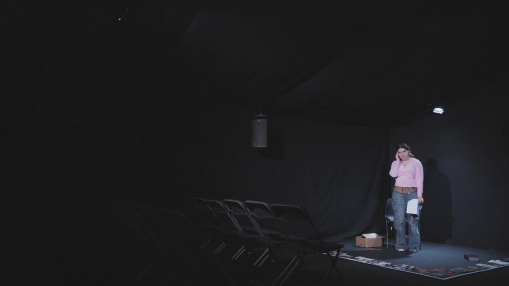 woman on a dark theater stage