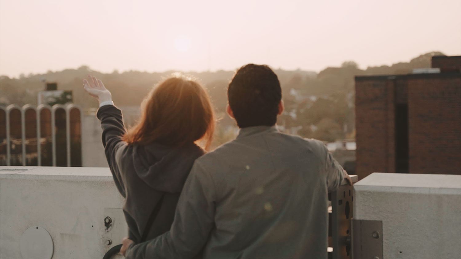 Couple looking out over a city skyline.
